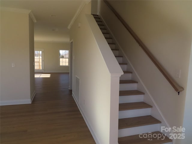 staircase featuring crown molding and wood-type flooring