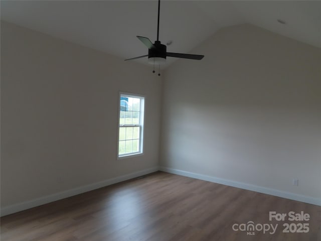 spare room with hardwood / wood-style flooring, lofted ceiling, and ceiling fan