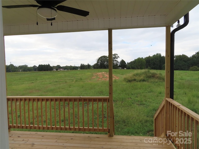 wooden deck with a rural view and ceiling fan