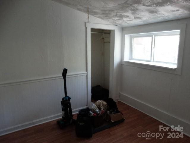 unfurnished bedroom with dark hardwood / wood-style flooring and a closet