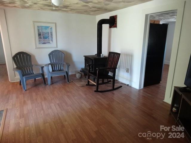 living area with hardwood / wood-style flooring and a wood stove