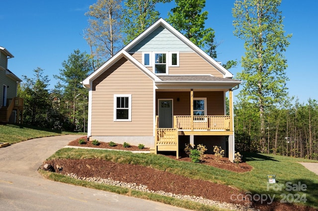 view of front of house with a front yard and covered porch