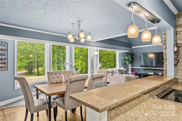 dining area with light wood-type flooring, vaulted ceiling, a notable chandelier, and a textured ceiling