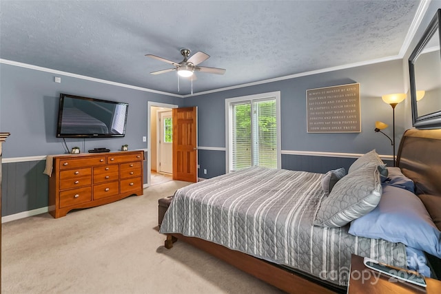 carpeted bedroom featuring ceiling fan, crown molding, and a textured ceiling