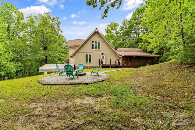 back of house featuring a yard, a fire pit, and a sunroom