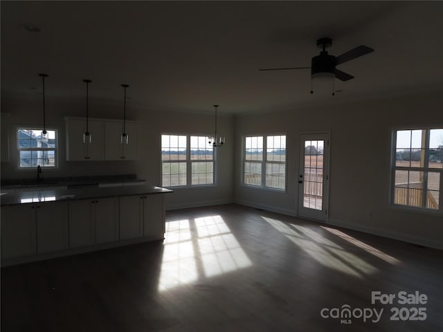 interior space featuring white cabinetry, decorative light fixtures, dark hardwood / wood-style flooring, and ceiling fan with notable chandelier