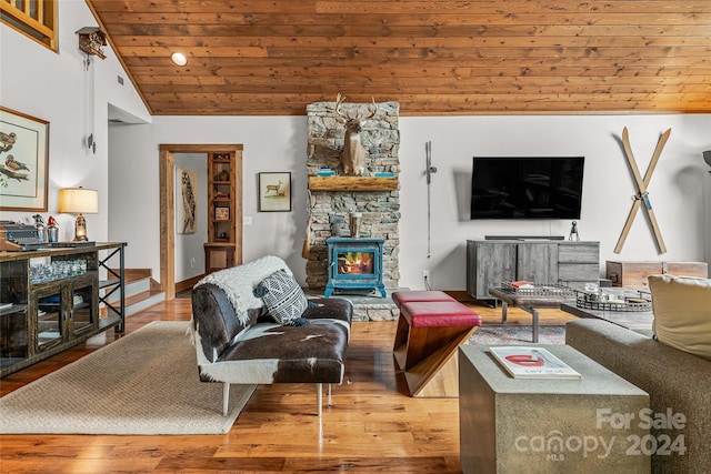 living room with wood ceiling, a wood stove, wood-type flooring, and vaulted ceiling