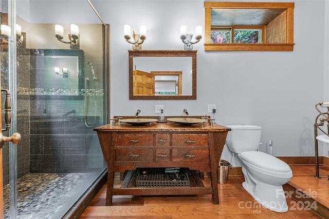 bathroom featuring dual bowl vanity, walk in shower, and toilet