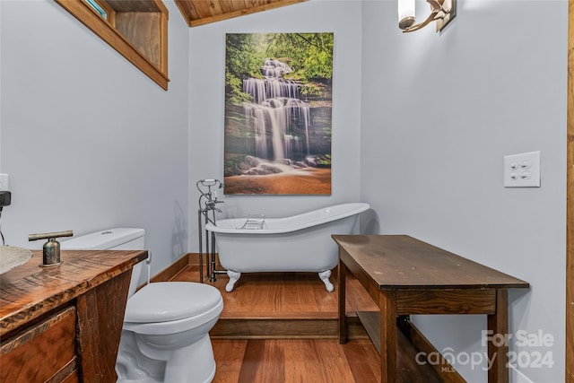 bathroom featuring lofted ceiling, a bathing tub, toilet, and hardwood / wood-style floors