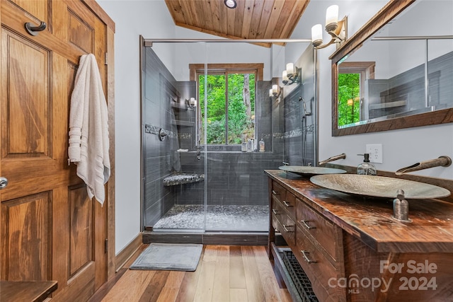 bathroom featuring vanity with extensive cabinet space, hardwood / wood-style flooring, wood ceiling, walk in shower, and lofted ceiling