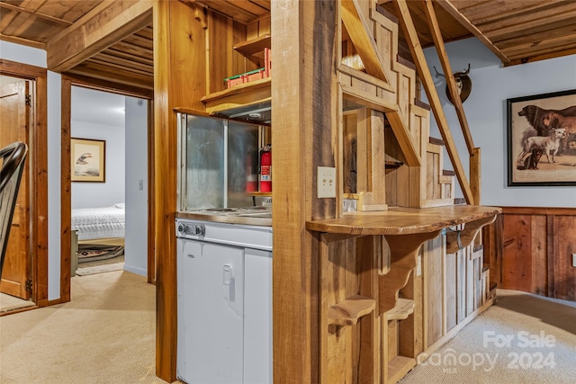 kitchen featuring a breakfast bar area, light carpet, and wooden ceiling