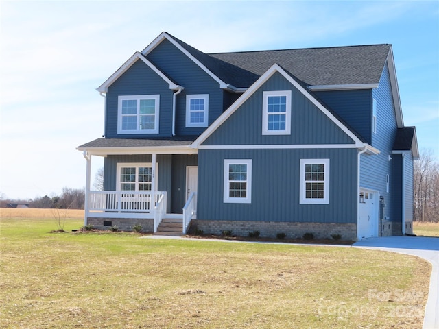 view of front of house with a garage, a front yard, and covered porch