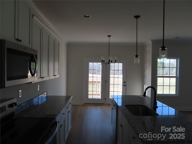 kitchen featuring pendant lighting, sink, crown molding, and stainless steel appliances