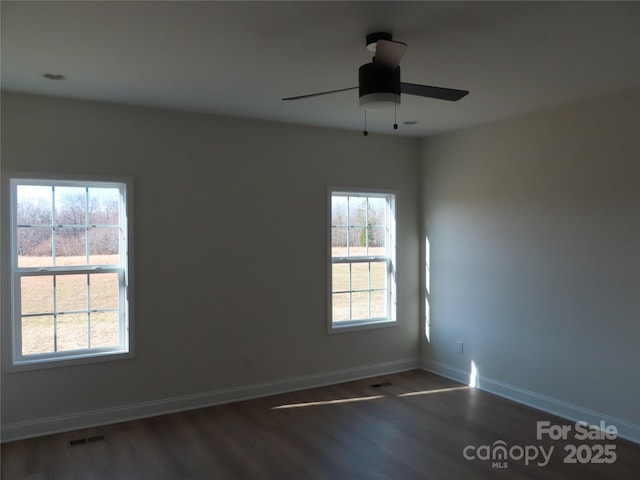 unfurnished room with dark hardwood / wood-style flooring and ceiling fan