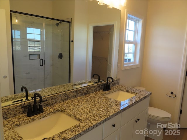 bathroom with walk in shower, vanity, and toilet