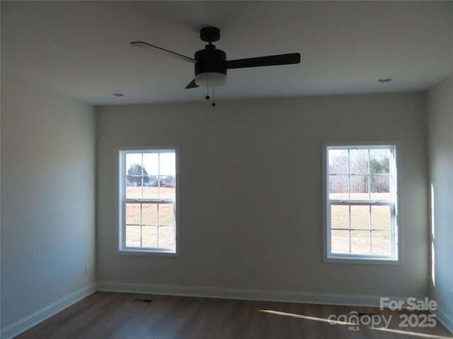 spare room with ceiling fan, dark hardwood / wood-style floors, and a wealth of natural light