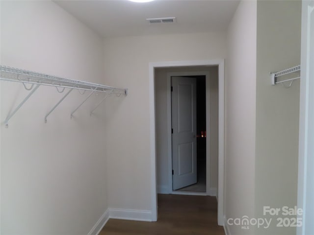 spacious closet with dark hardwood / wood-style floors