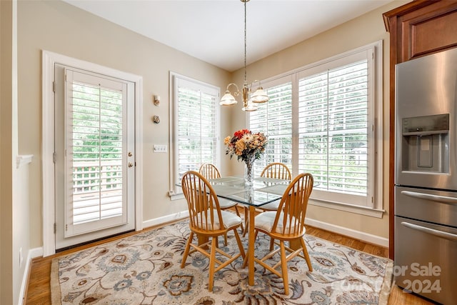 dining room with plenty of natural light, a chandelier, and light hardwood / wood-style floors