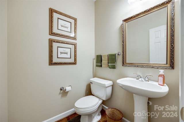 bathroom with toilet and wood-type flooring