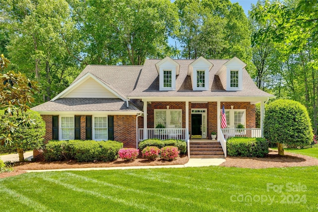 new england style home featuring a front yard and a porch