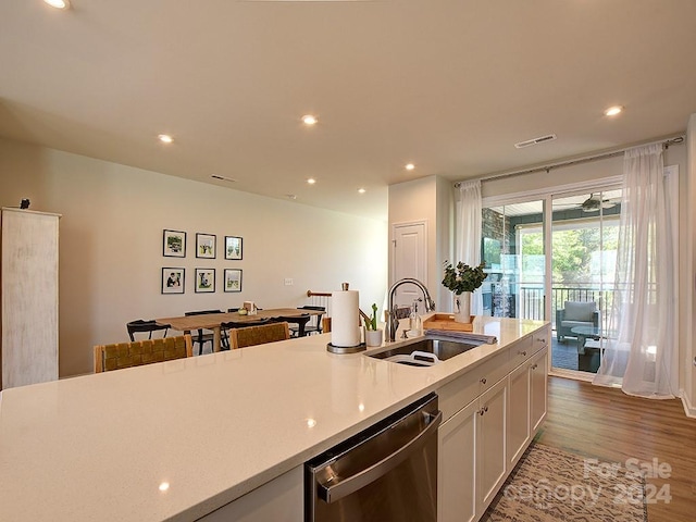 kitchen featuring sink, light wood-type flooring, dishwasher, and white cabinetry