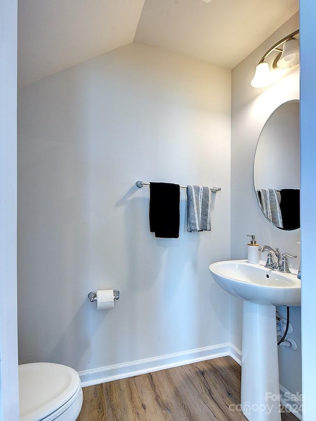 bathroom featuring hardwood / wood-style flooring, toilet, and lofted ceiling