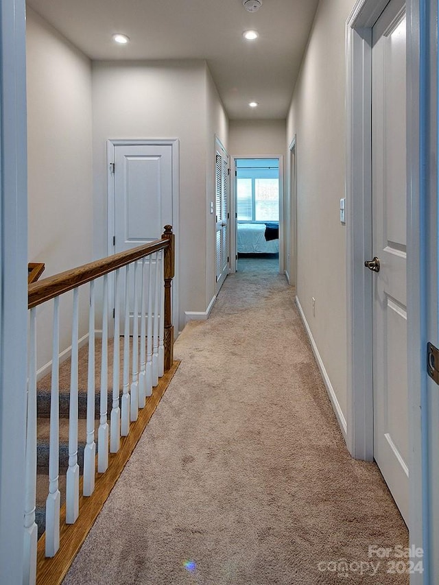 hallway featuring light colored carpet