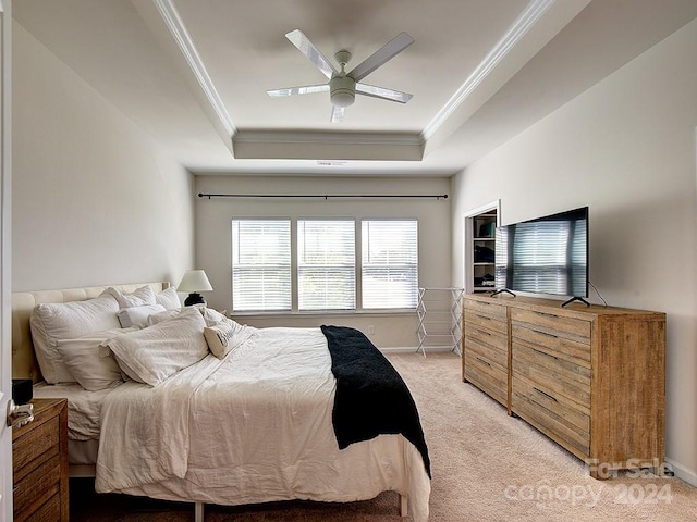 carpeted bedroom featuring ornamental molding, ceiling fan, and a raised ceiling