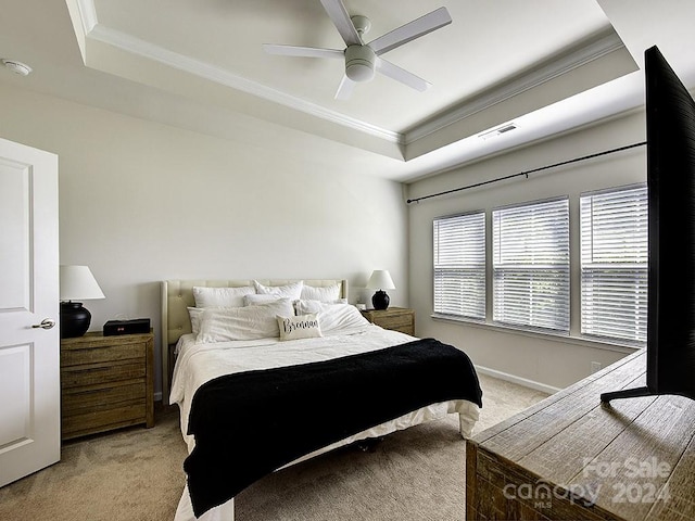 bedroom featuring carpet, ceiling fan, a tray ceiling, and ornamental molding