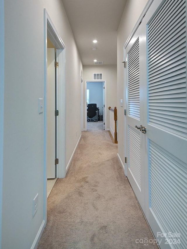 hallway featuring light colored carpet