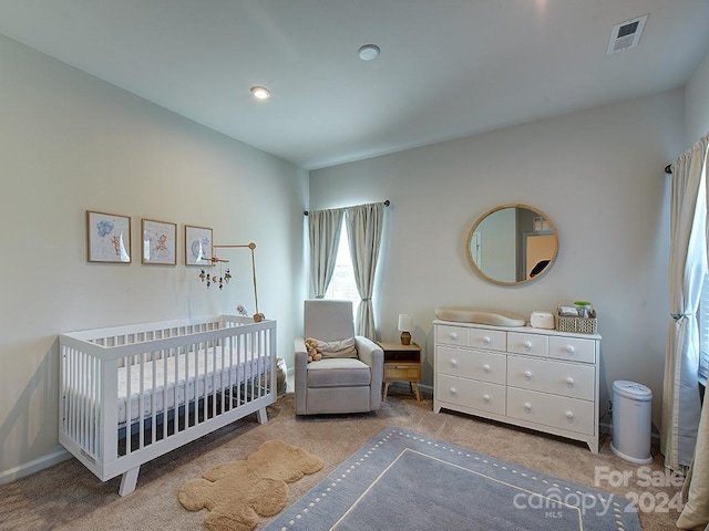 bedroom featuring carpet flooring and a crib