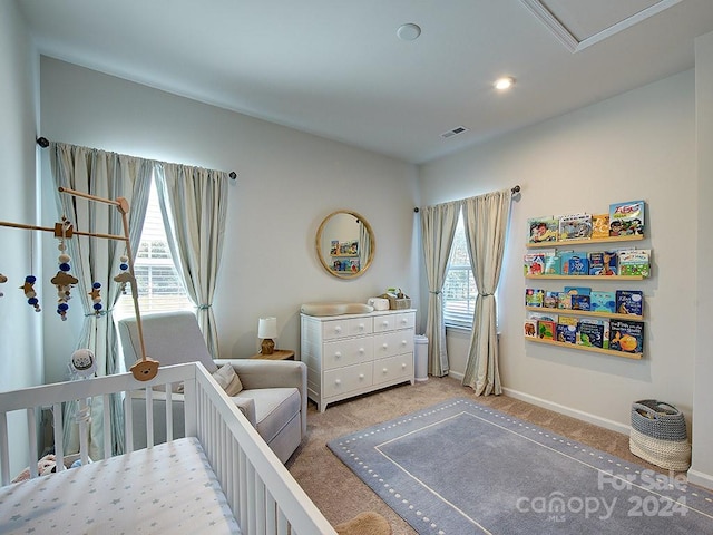 bedroom featuring carpet and a crib