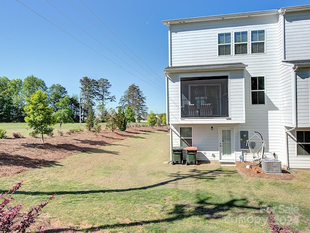 back of property featuring central AC unit and a yard