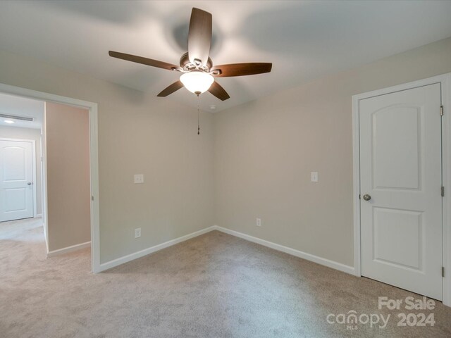 spare room featuring ceiling fan and light carpet