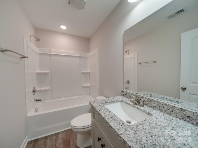 full bathroom with bathtub / shower combination, wood-type flooring, vanity, and toilet