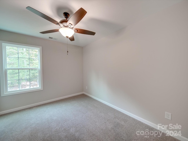 carpeted spare room featuring ceiling fan