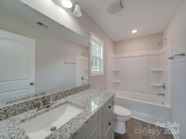 full bathroom featuring wood-type flooring, vanity, toilet, and  shower combination