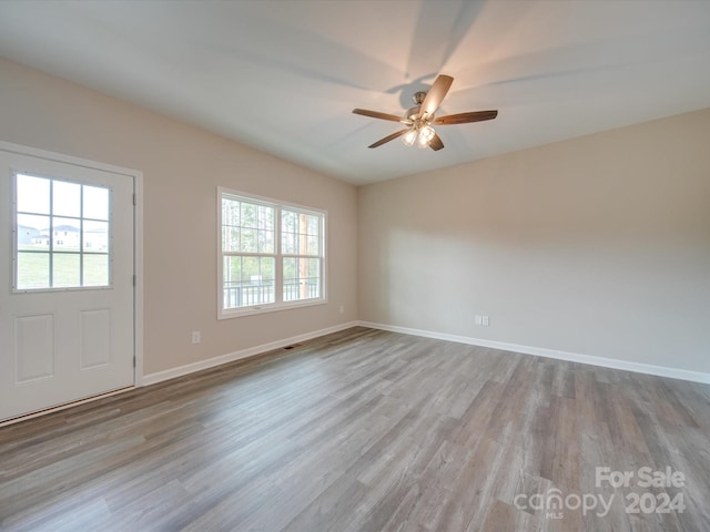 spare room with light hardwood / wood-style floors, ceiling fan, and plenty of natural light