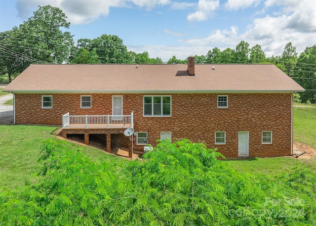 back of house featuring a wooden deck and a yard