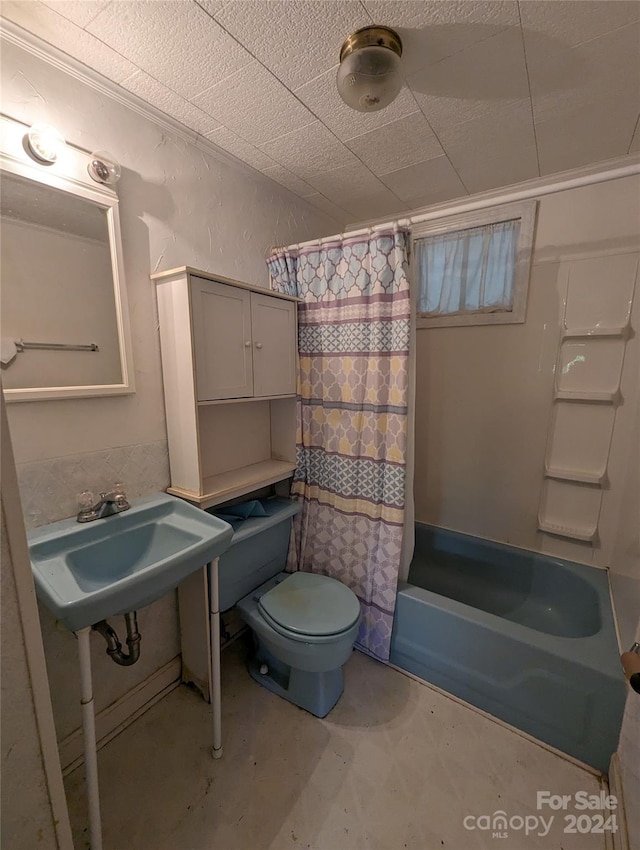 full bathroom with shower / bathtub combination with curtain, toilet, concrete flooring, sink, and a paneled ceiling