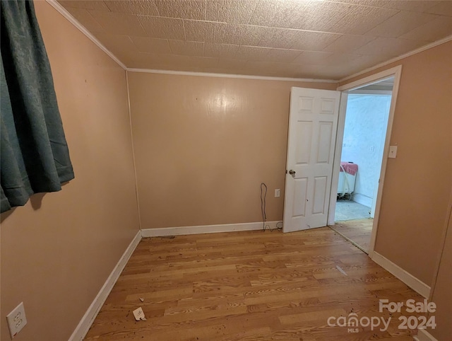 spare room with crown molding and hardwood / wood-style flooring