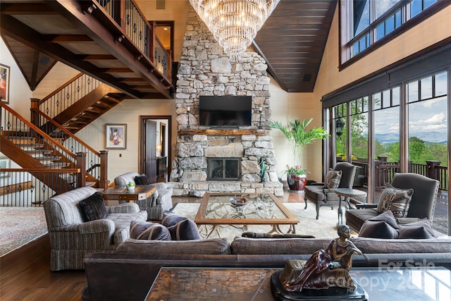 living room with high vaulted ceiling, a fireplace, a chandelier, and wood-type flooring