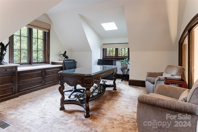 home office with vaulted ceiling with skylight and carpet floors