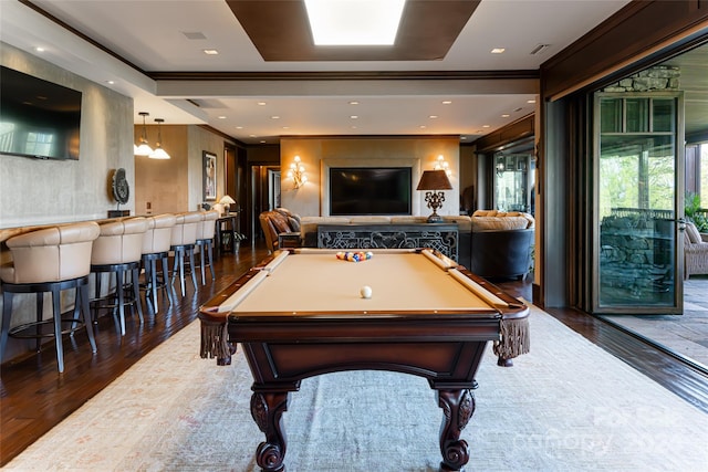 recreation room with ornamental molding, dark wood-type flooring, bar, and pool table