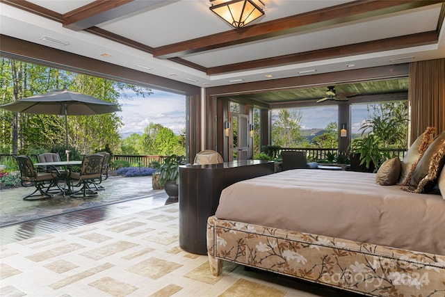 bedroom with beamed ceiling, multiple windows, and access to exterior