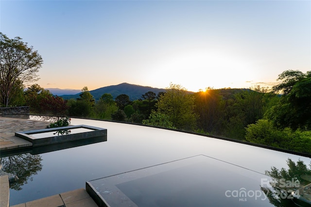 pool at dusk with a mountain view