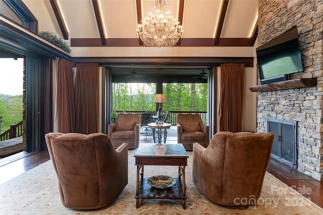 living room featuring a fireplace, ceiling fan with notable chandelier, beamed ceiling, hardwood / wood-style floors, and high vaulted ceiling