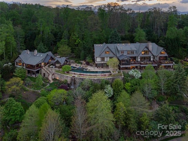 birds eye view of property featuring a wooded view