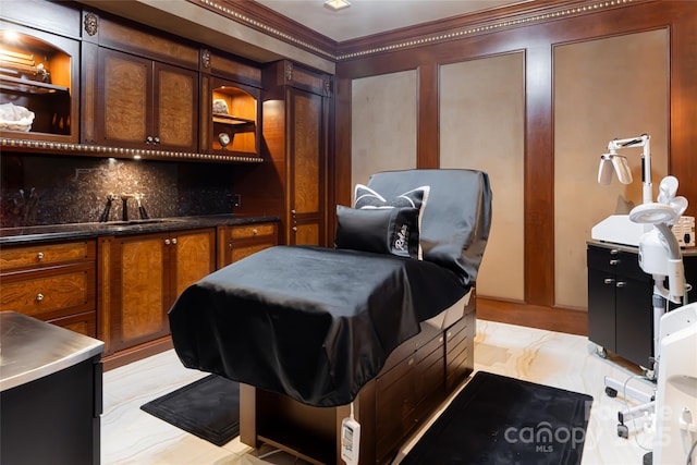 interior space featuring crown molding, a sink, and decorative backsplash