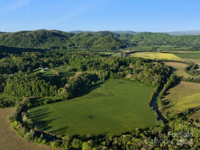 drone / aerial view with a wooded view and a mountain view